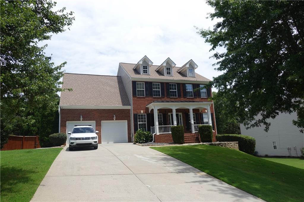 a front view of a house with a yard and trees