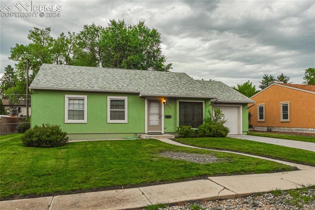 Single story home featuring a front yard and a garage