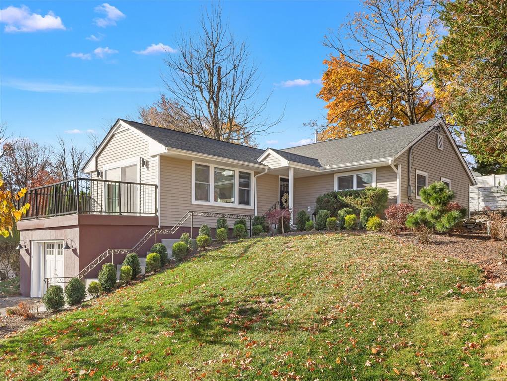 View of front of home with a garage and a front lawn