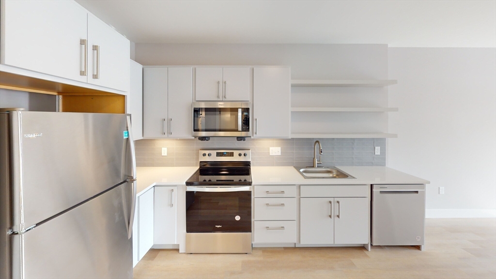 a kitchen with white cabinets and stainless steel appliances