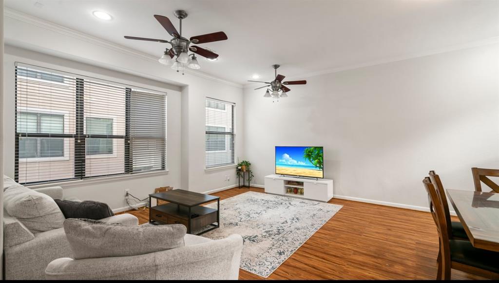 a living room with furniture ceiling fan and a window