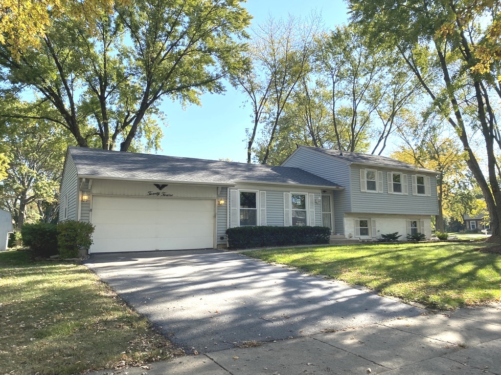 a front view of a house with yard and green space