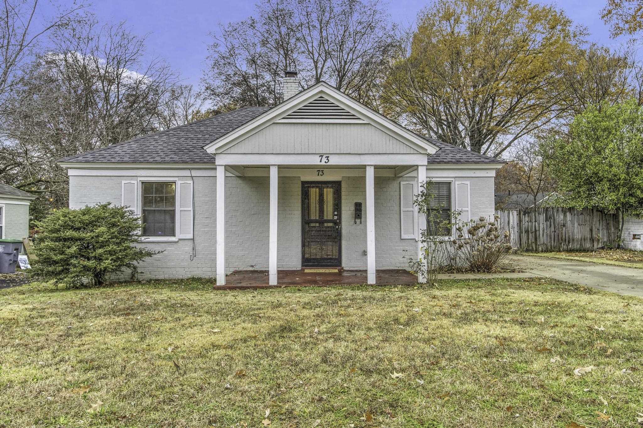 a front view of house with yard and trees around