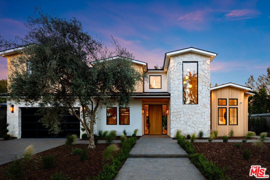 a front view of a house with a garden