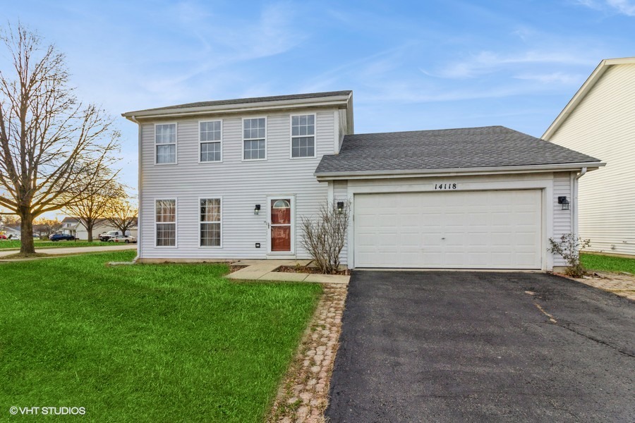 a front view of a house with a yard and garage