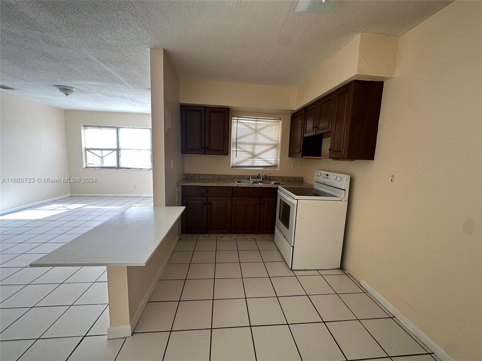 a kitchen with a sink a stove and cabinets