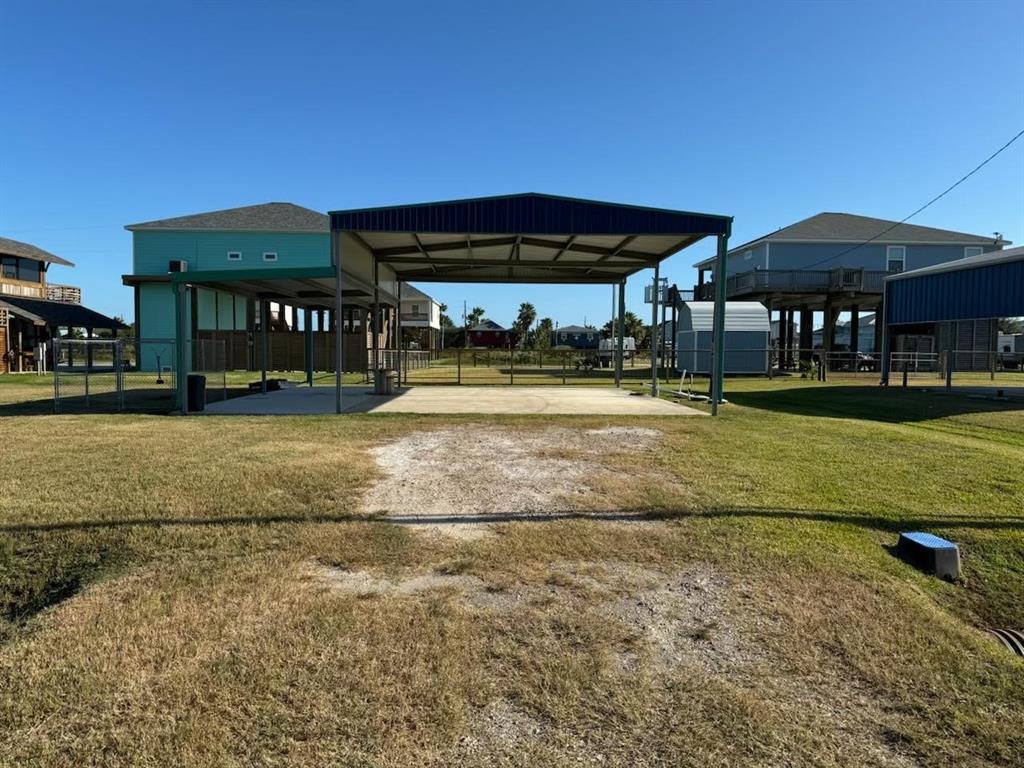 a view of a big yard with table and chairs under an umbrella