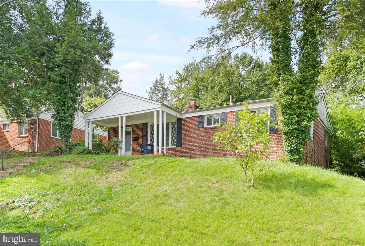 a front view of a house with a yard and trees