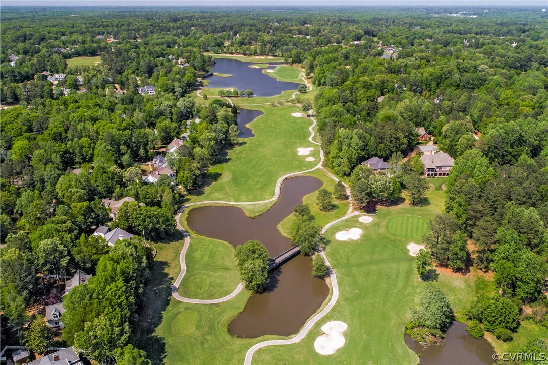 an aerial view of residential house with outdoor space and trees all around