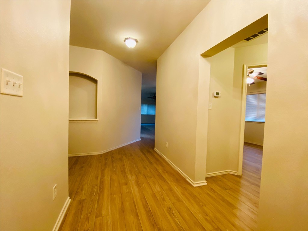 a view of an empty room with wooden floor