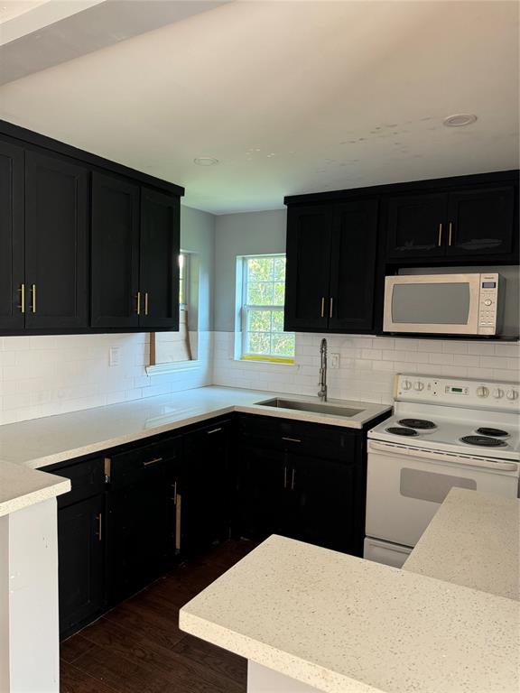 a kitchen with a sink a stove and cabinets