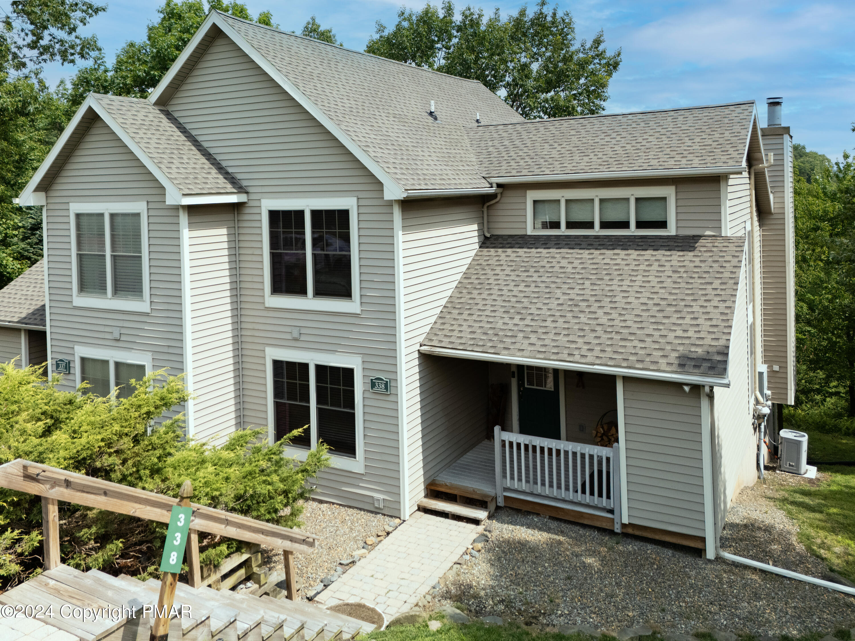 a front view of house with stairs and yard