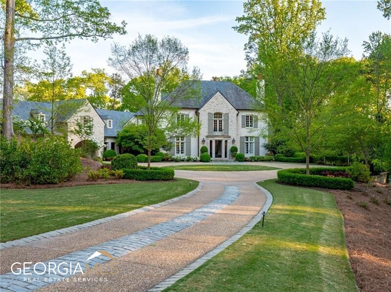 a front view of a house with yard and green space