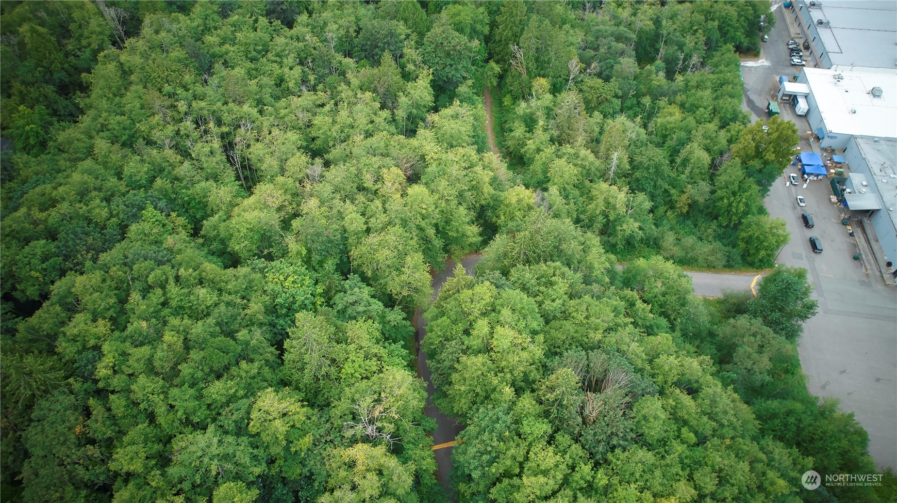 an aerial view of residential house with outdoor space and trees all around