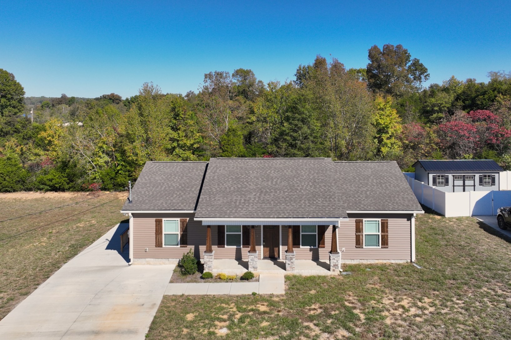 aerial view of a house with a yard patio and fire pit