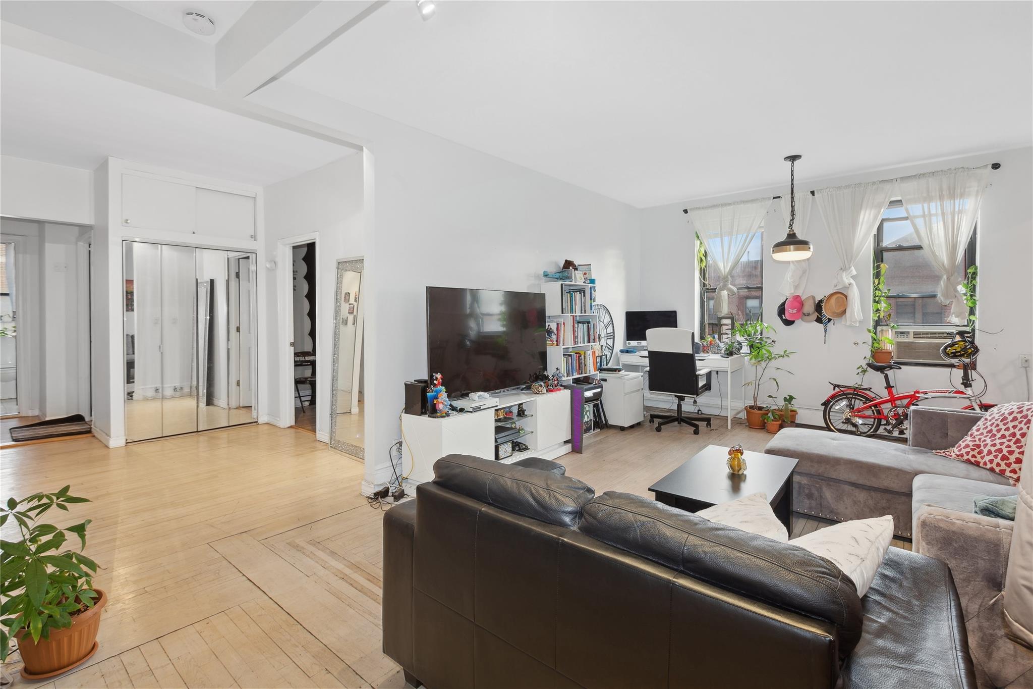 Living room featuring beamed ceiling and light parquet floors