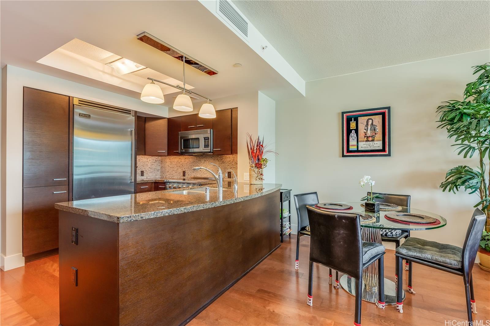 a kitchen with granite countertop a sink cabinets and stainless steel appliances