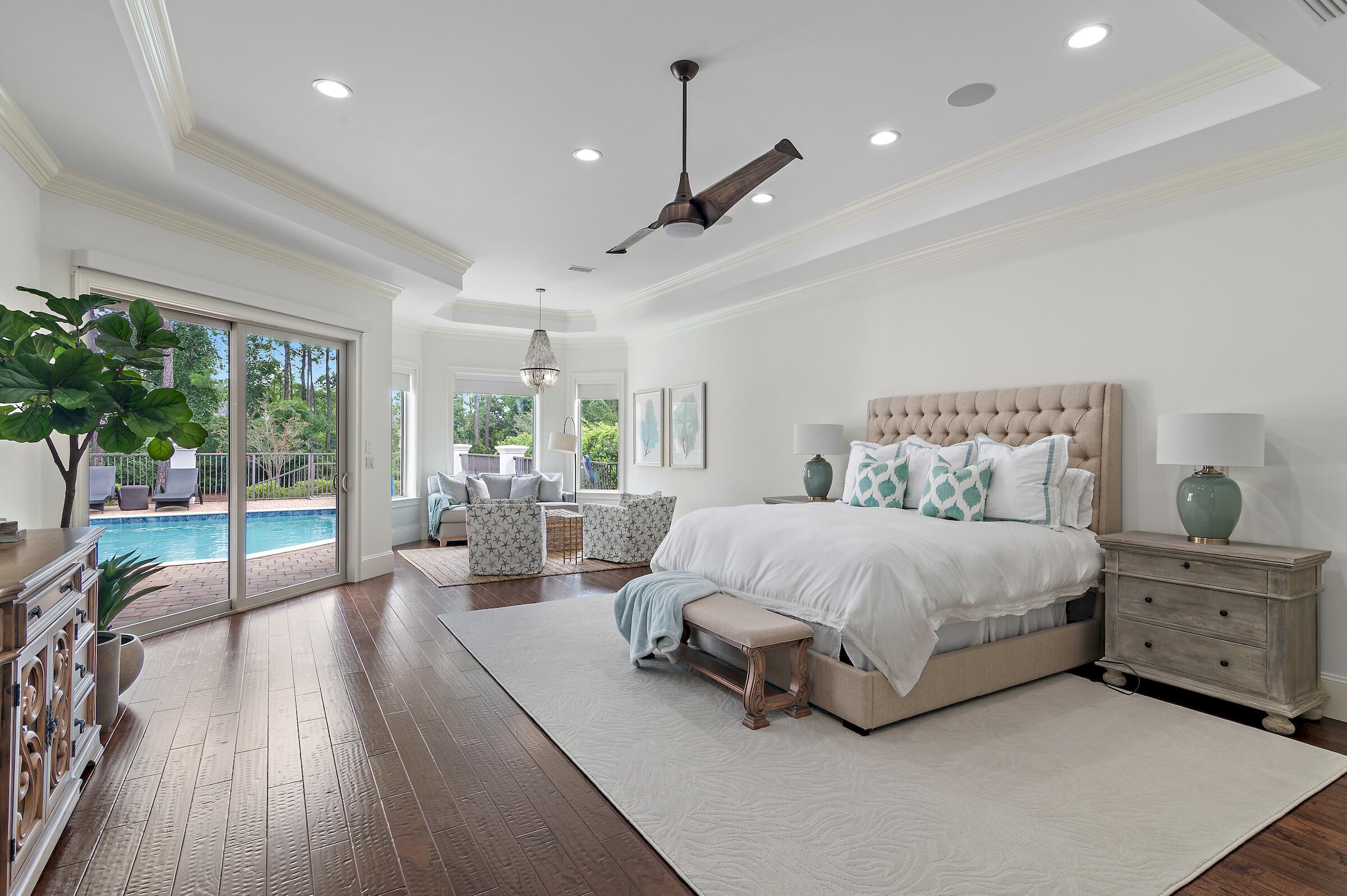 a spacious bedroom with a bed a chandelier and a large window