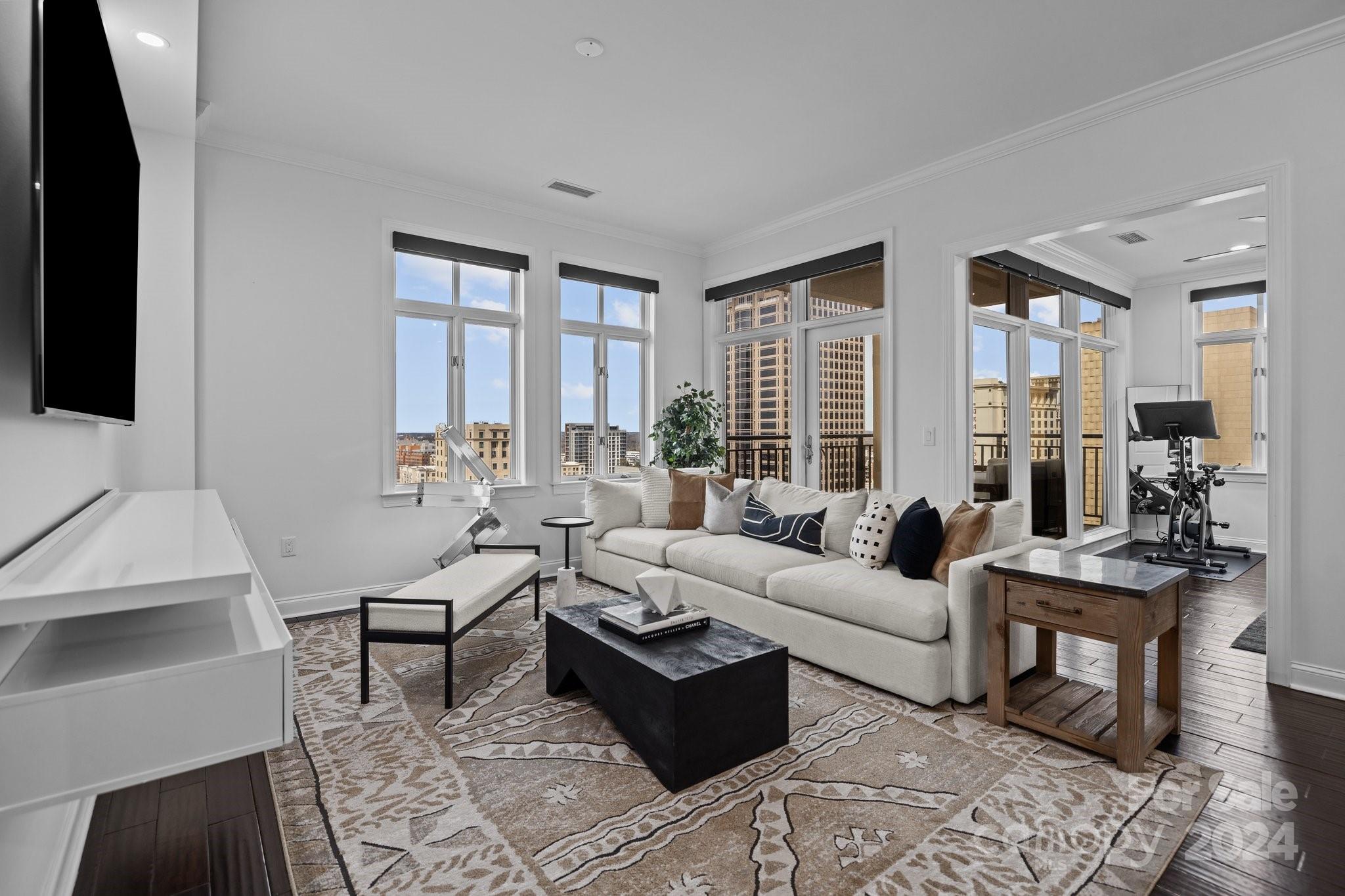 a living room with furniture wooden floor and a flat screen tv