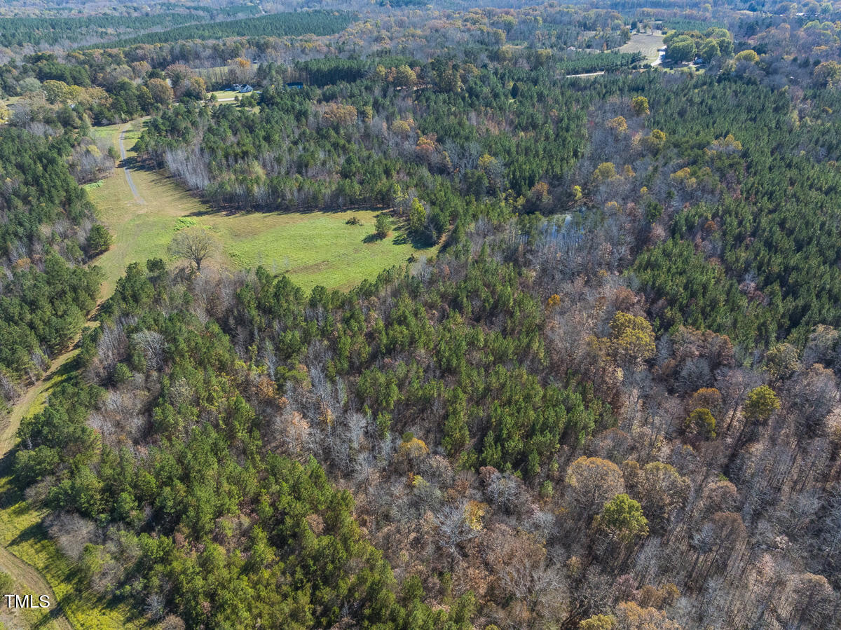 an aerial view of residential house with outdoor space and trees all around