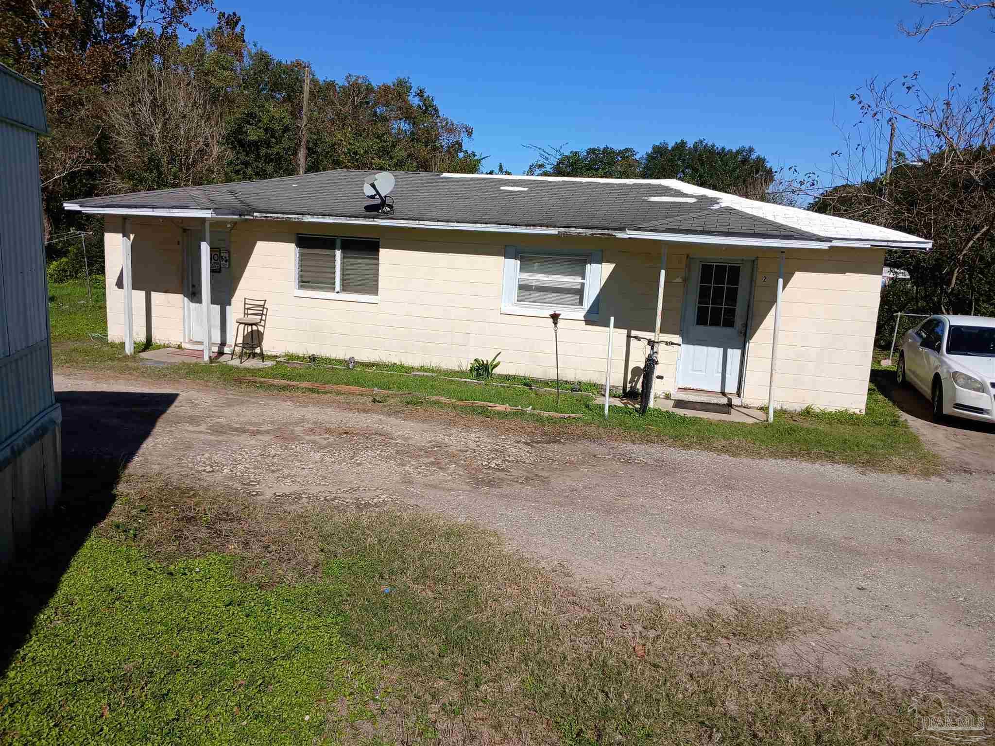 a view of a house with backyard and a tree