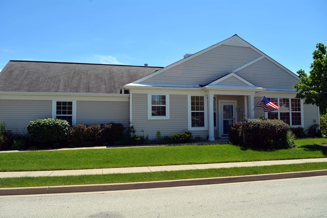 a view of a house with a big yard plants and large trees