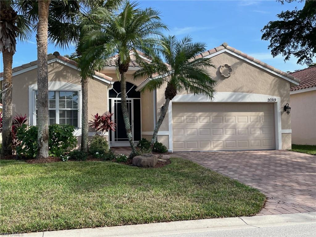 a view of a house with a yard and palm trees