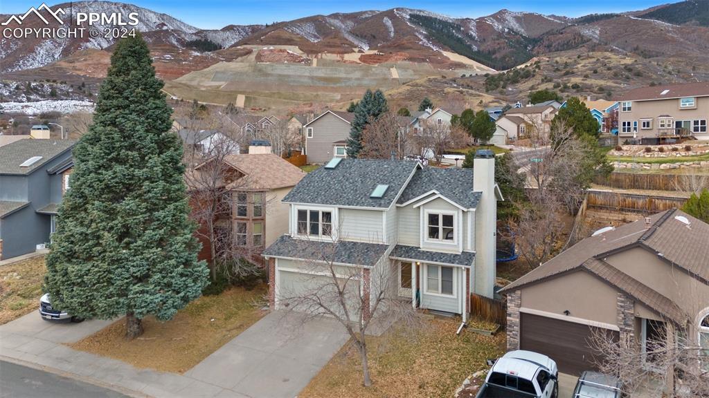 an aerial view of a house with a yard and mountain view