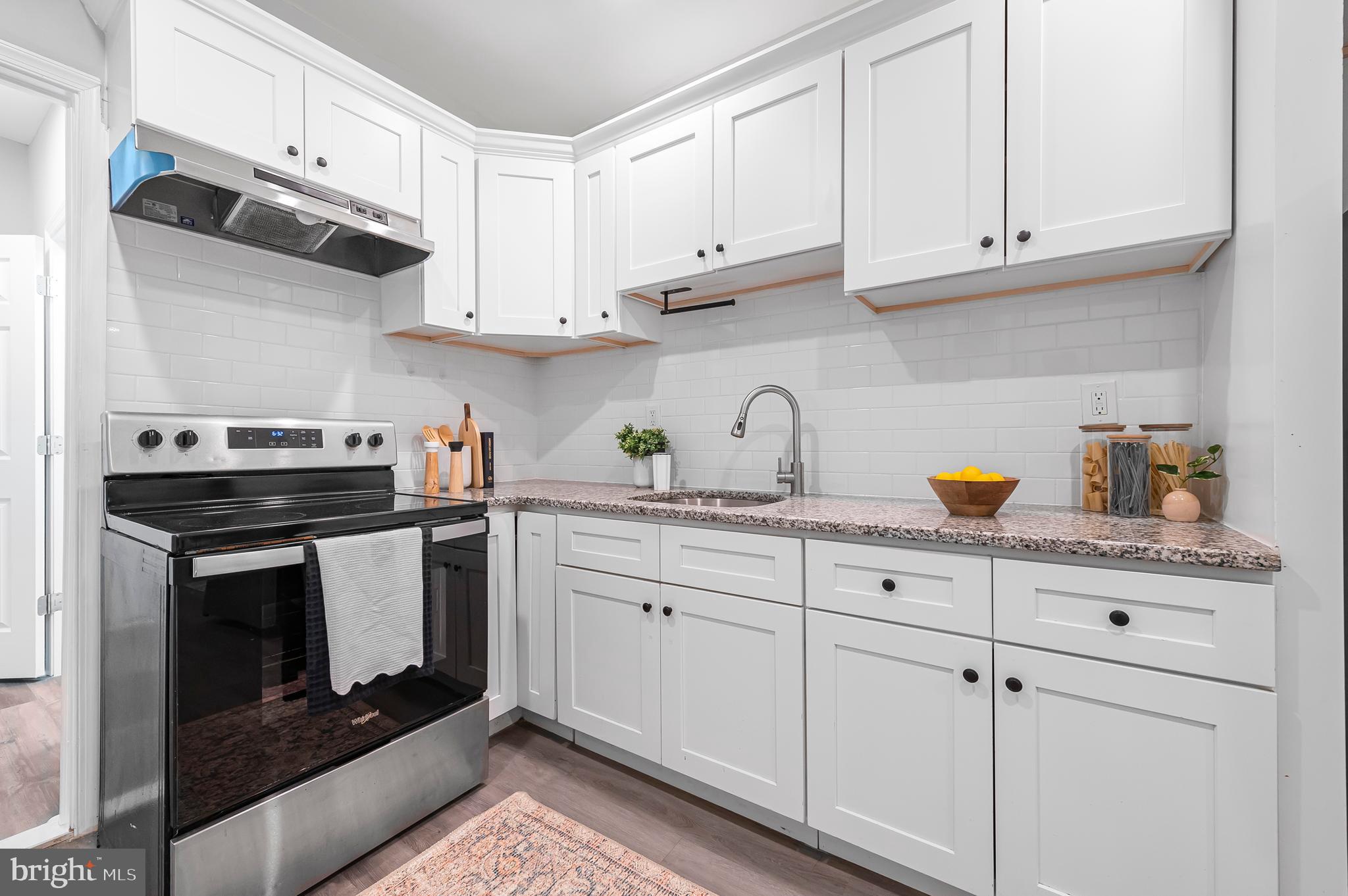 a kitchen with white cabinets and white appliances