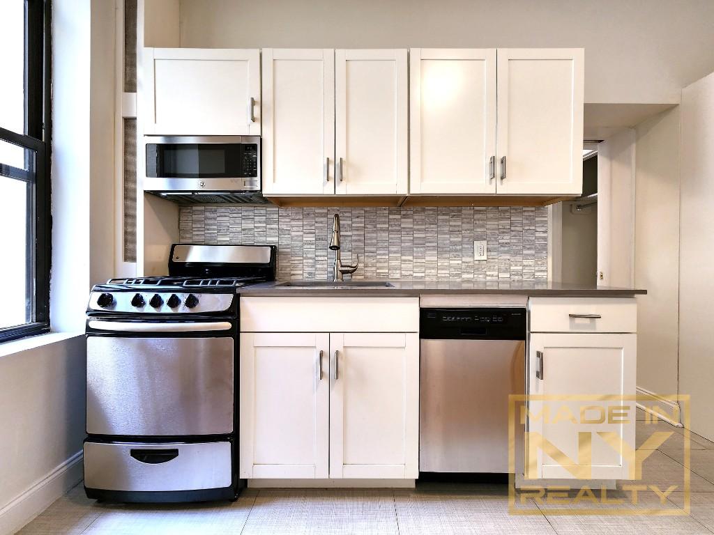 a kitchen with stainless steel appliances granite countertop a stove and a microwave