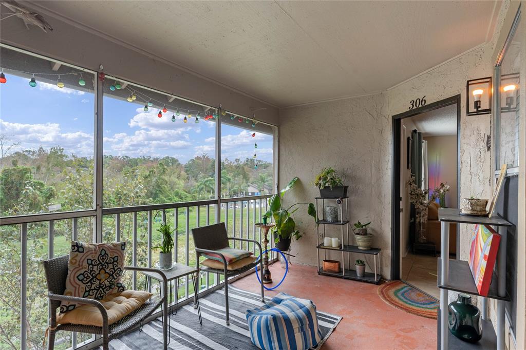 a living room with furniture a flat screen tv and a floor to ceiling window