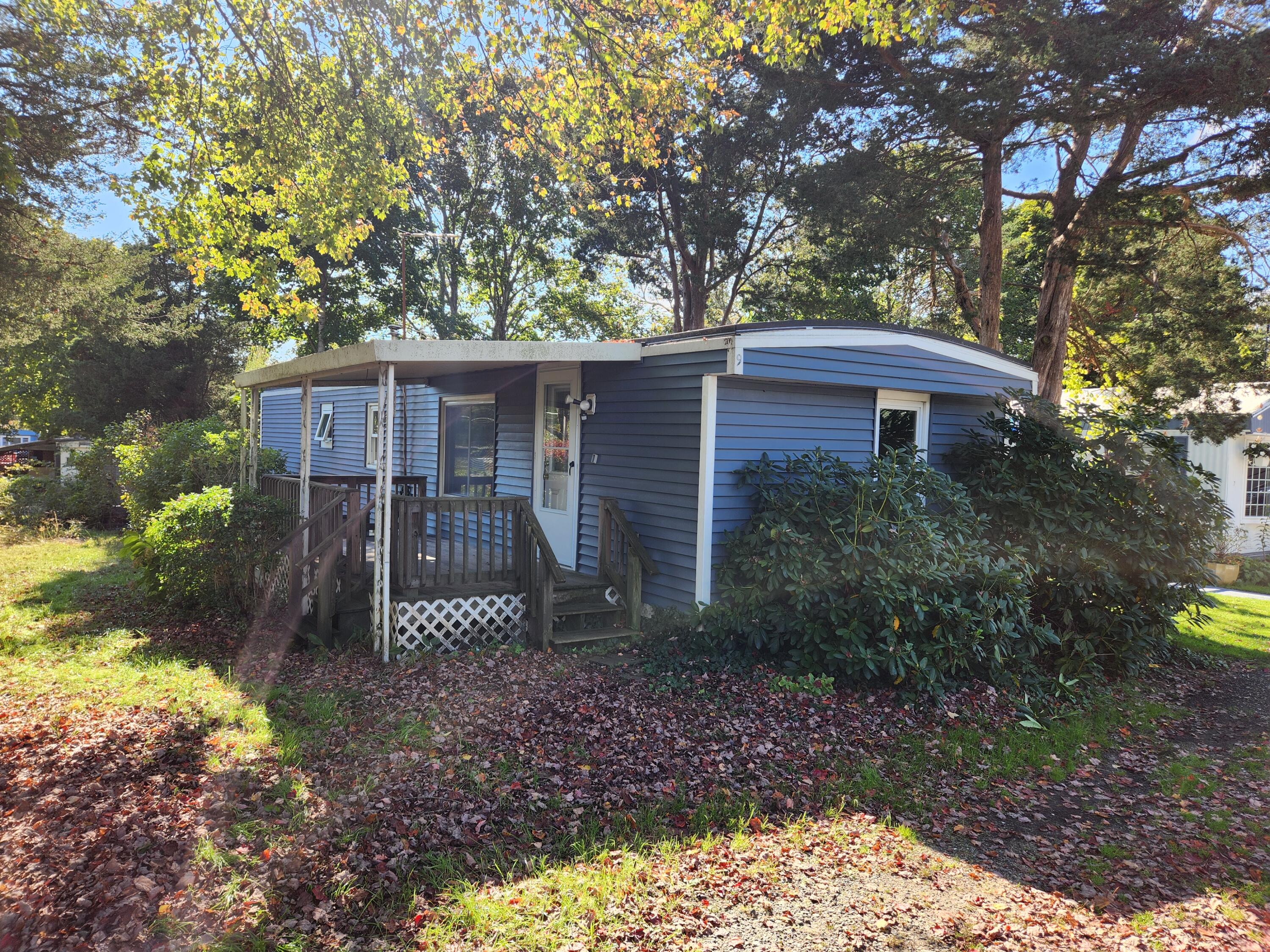 a view of a house with a yard and large tree