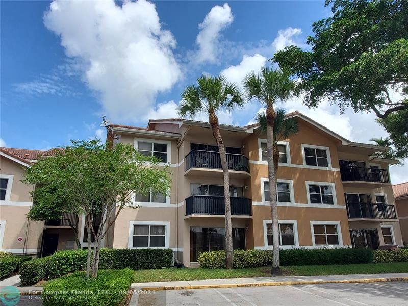 a front view of a residential apartment building with a yard