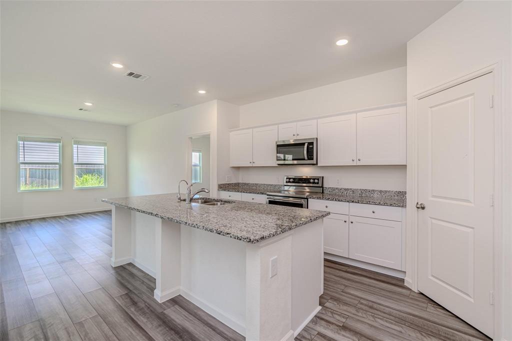 a kitchen with stainless steel appliances granite countertop a stove a sink and a granite counter tops