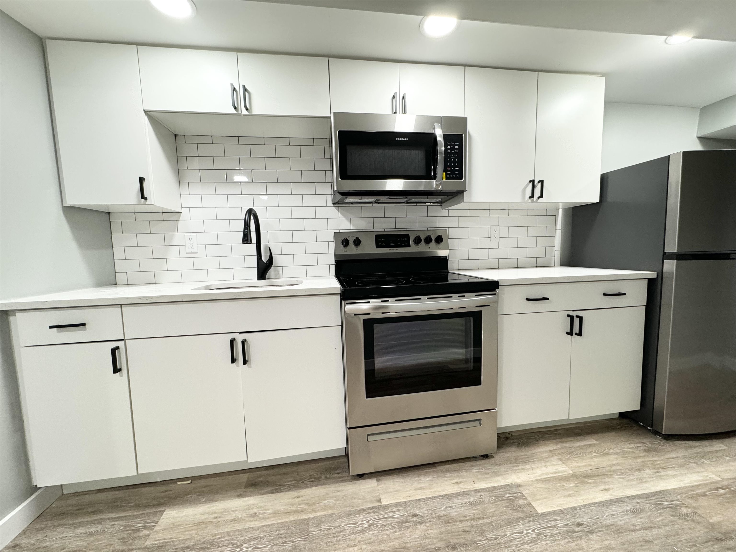 a kitchen with a sink a stove and refrigerator