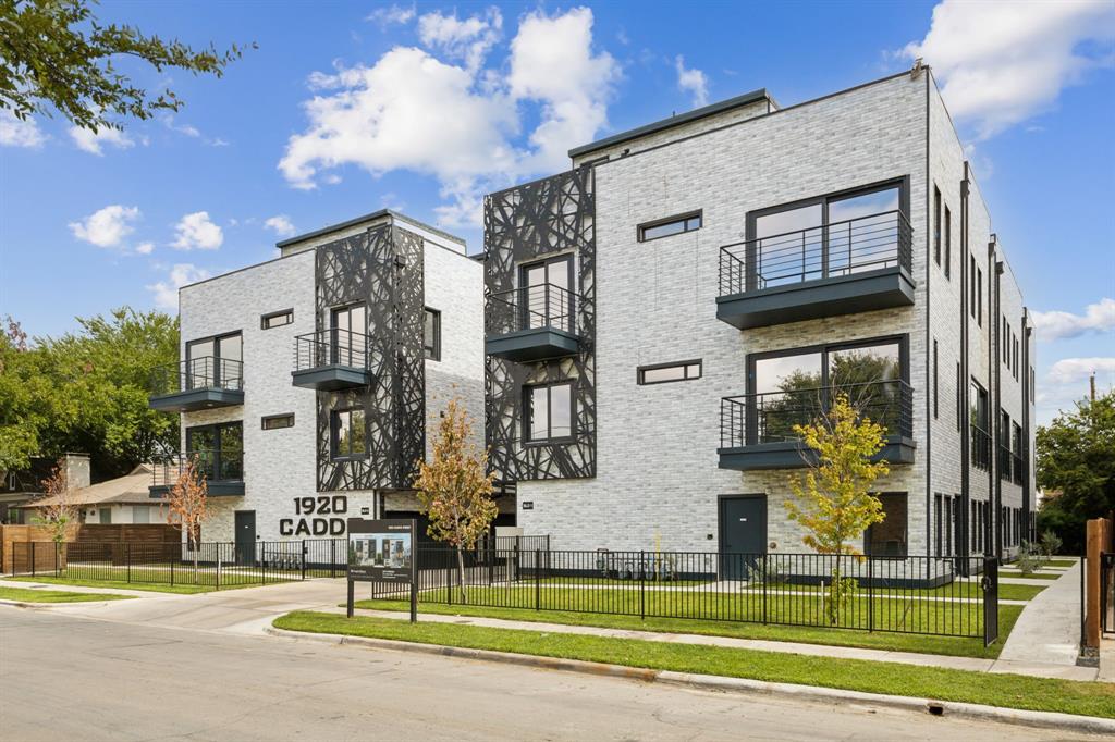 a front view of a building with street view and trees