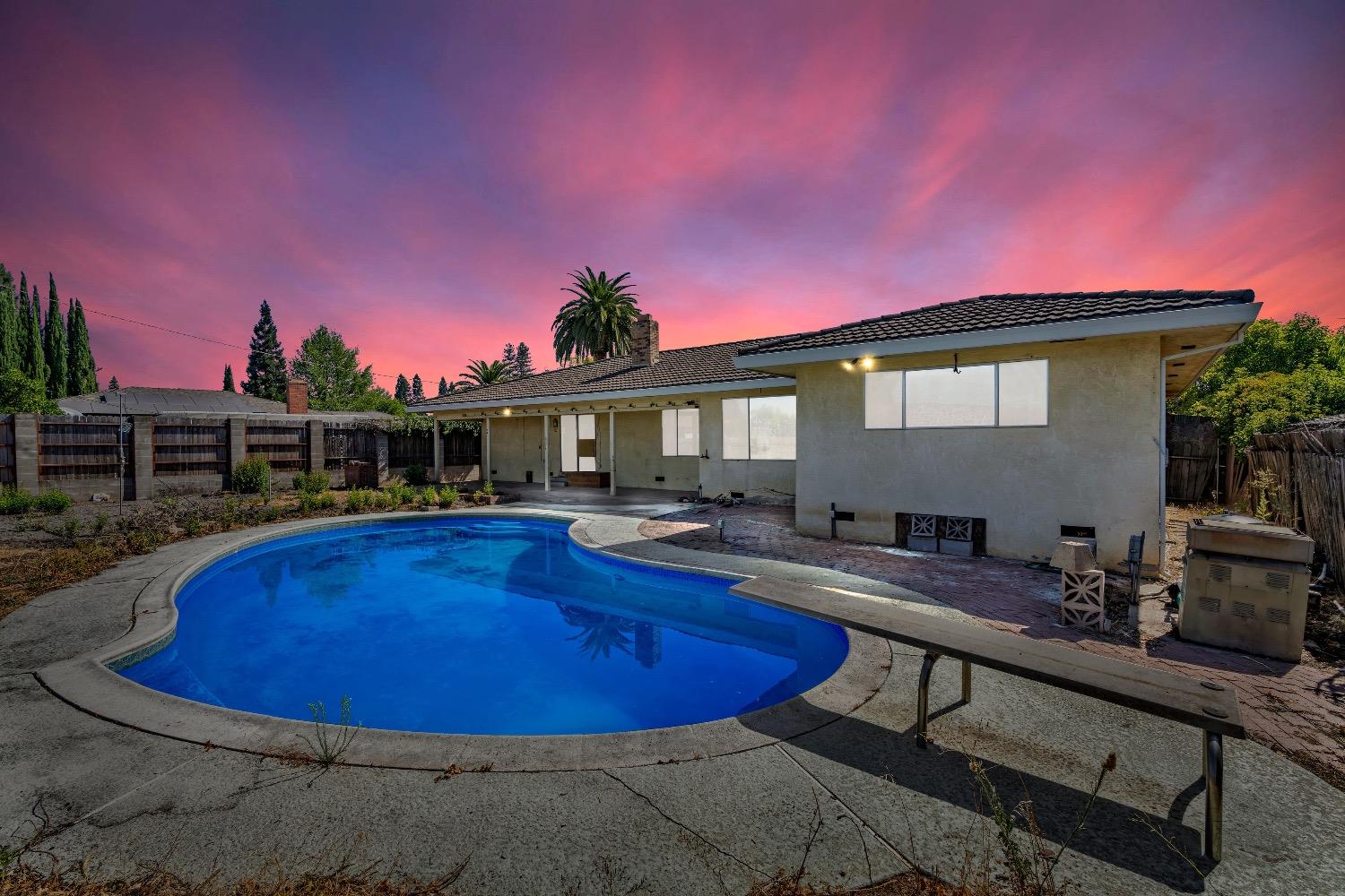 a view of a house with swimming pool and sitting area