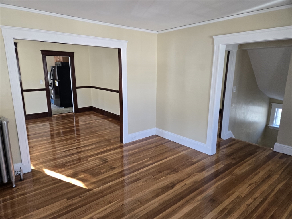 a view of a room with wooden floor and a hallway