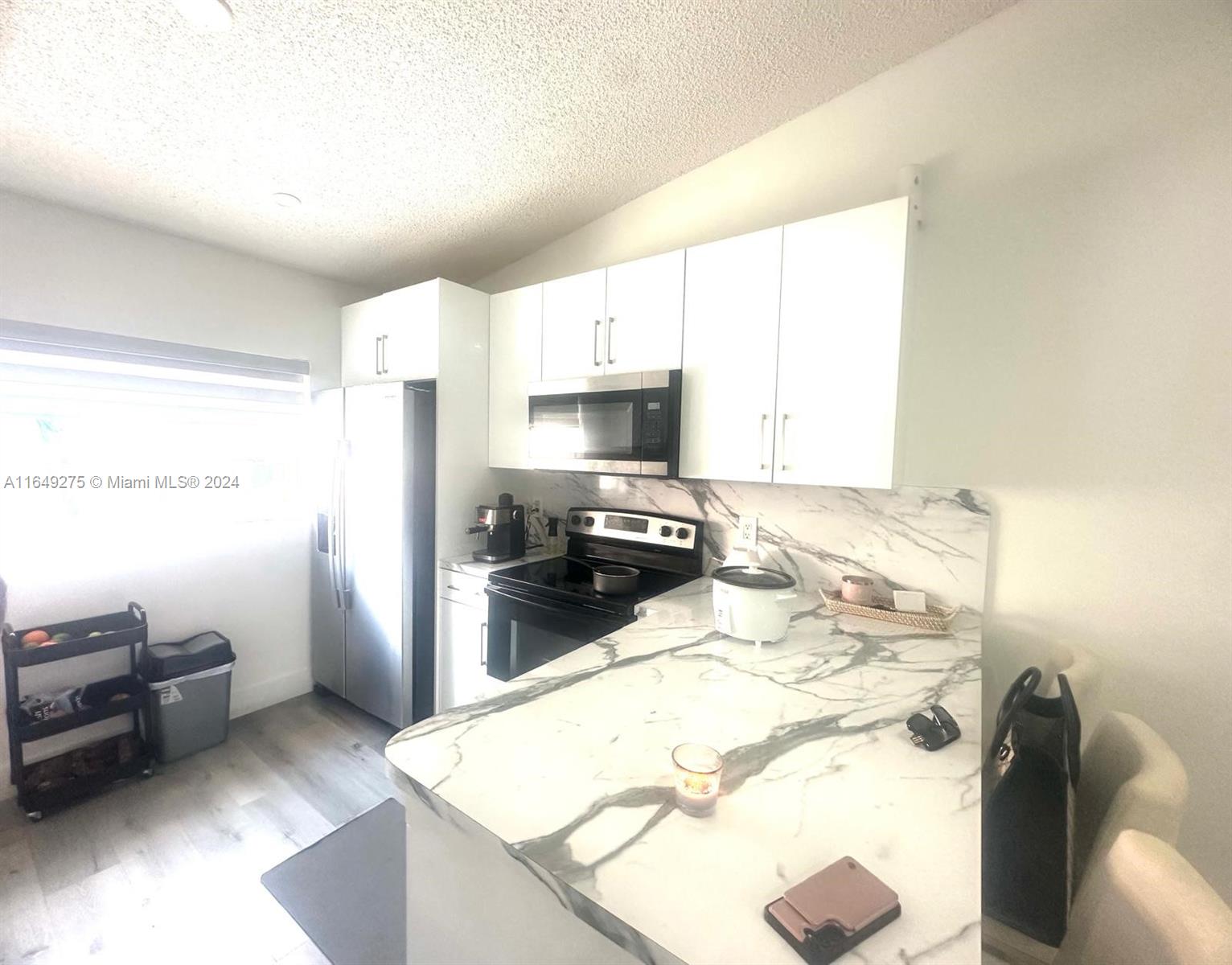 a kitchen with granite countertop a sink a stove and a refrigerator