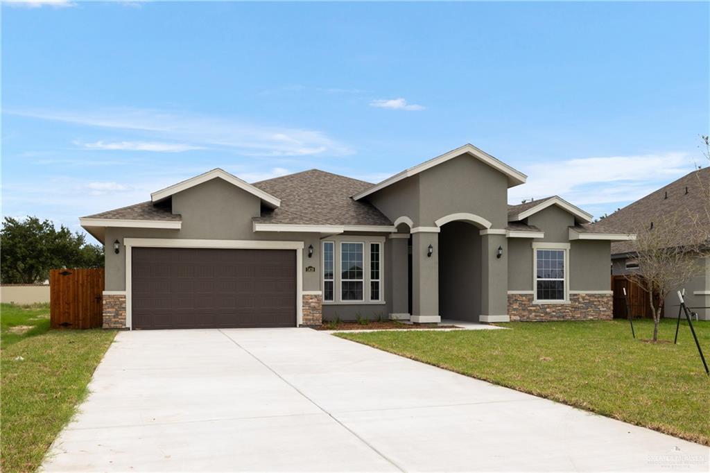 a front view of a house with a yard and garage