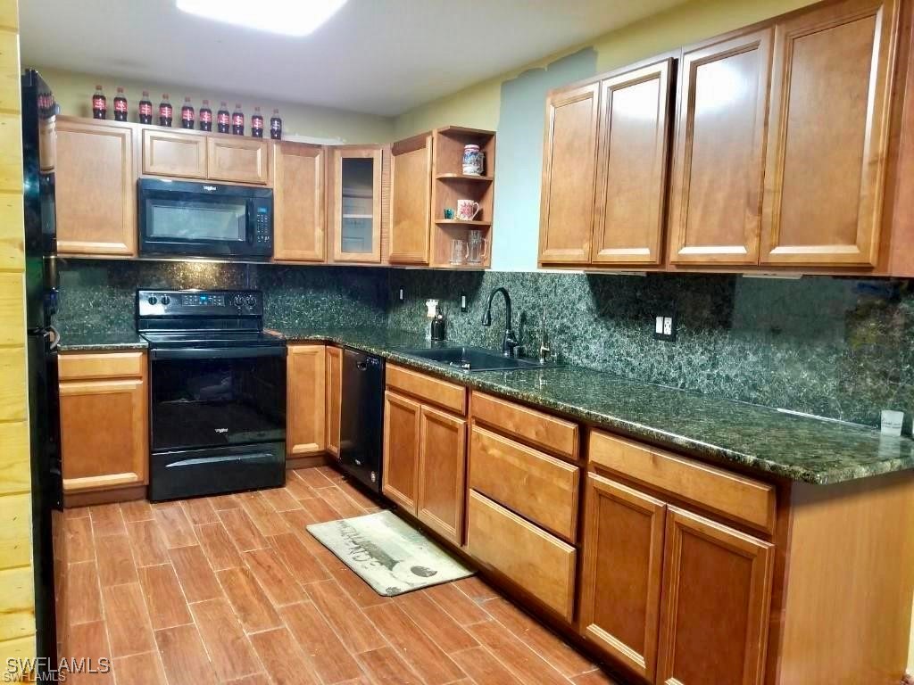 a kitchen with stainless steel appliances granite countertop a sink and a stove