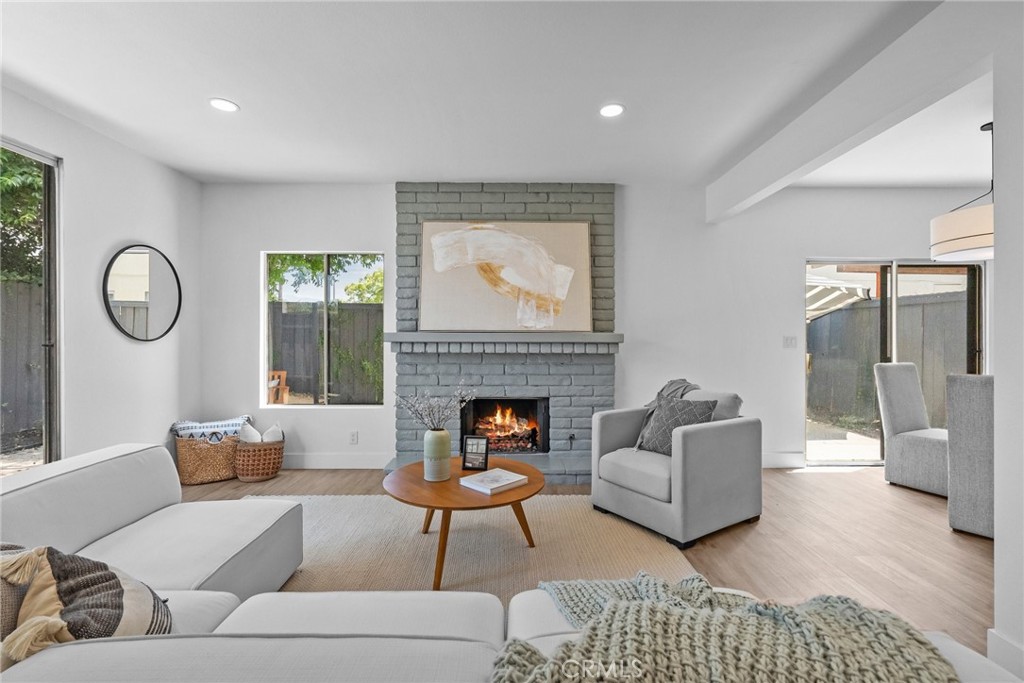 a living room with furniture a fireplace and a large window