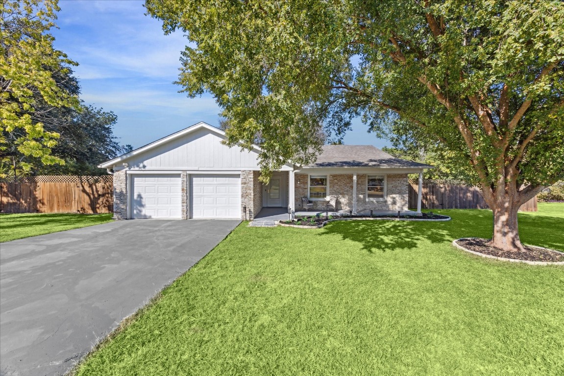 a front view of a house with yard and green space