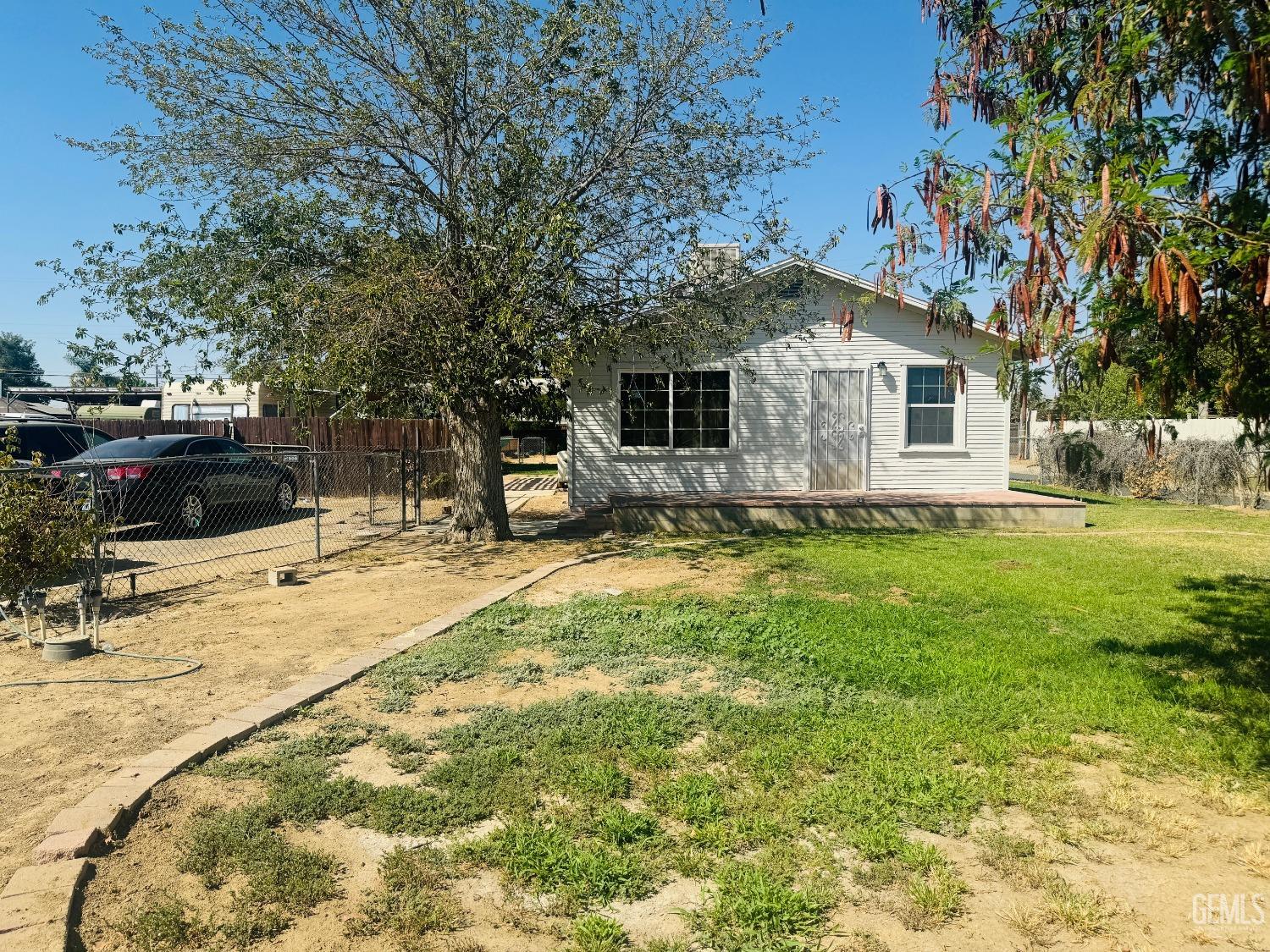 a front view of house with yard and trees around