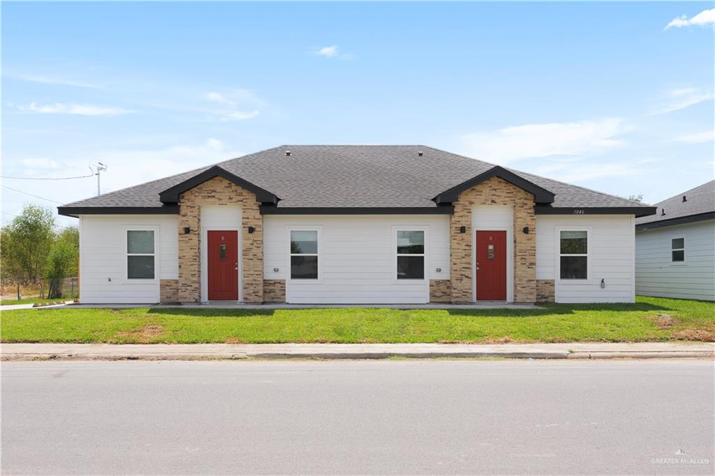 a front view of house with yard and trees around