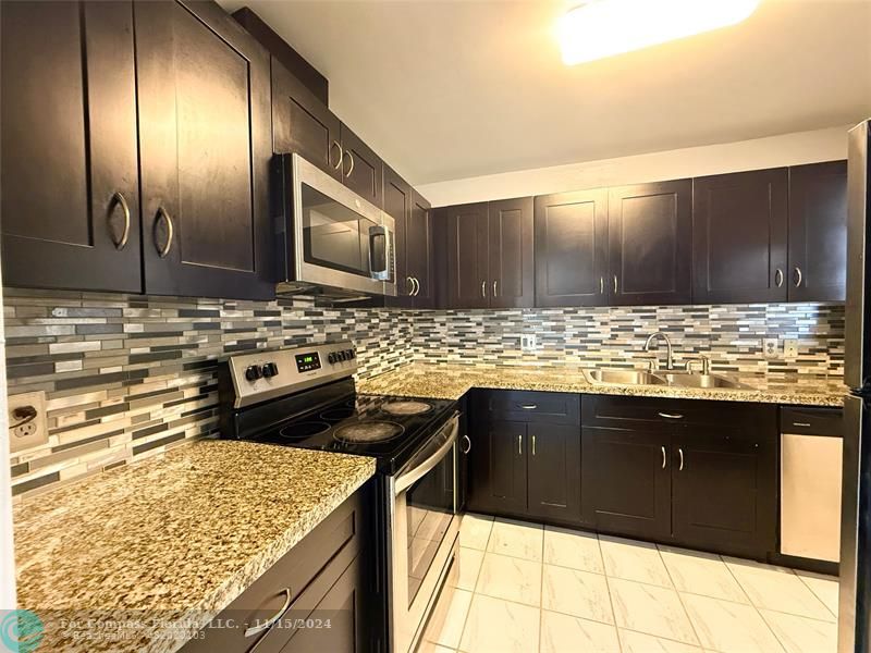 a kitchen with granite countertop stainless steel appliances and cabinets