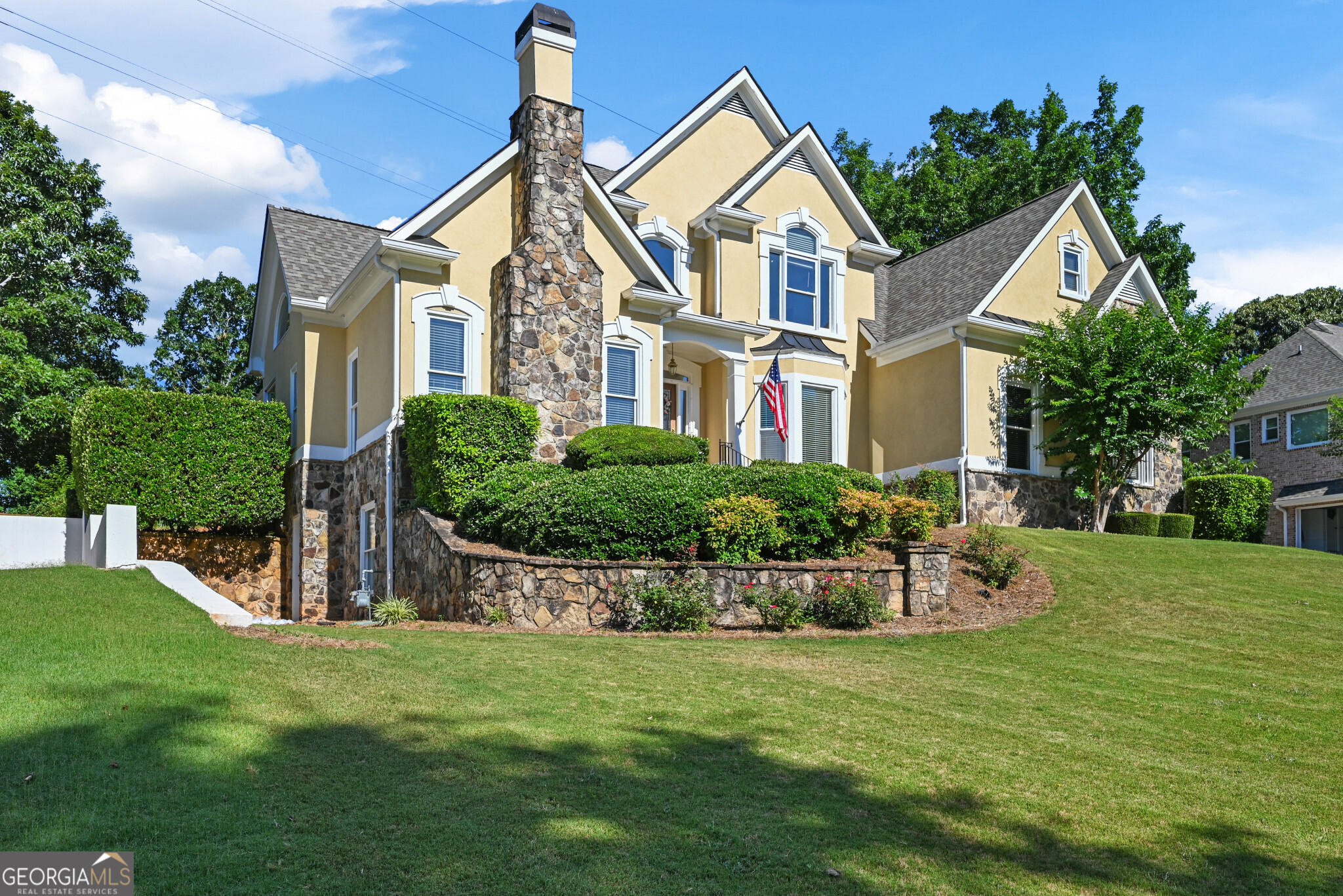 a front view of a house with a garden and plants