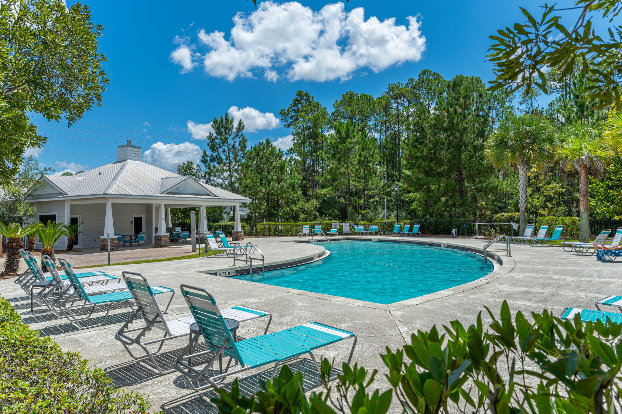 a view of a swimming pool with lawn chairs under an umbrella