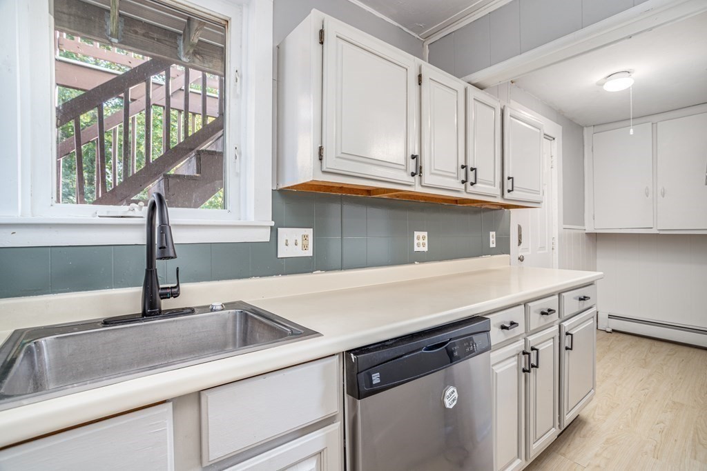 a kitchen with stainless steel appliances granite countertop a sink and a white cabinets