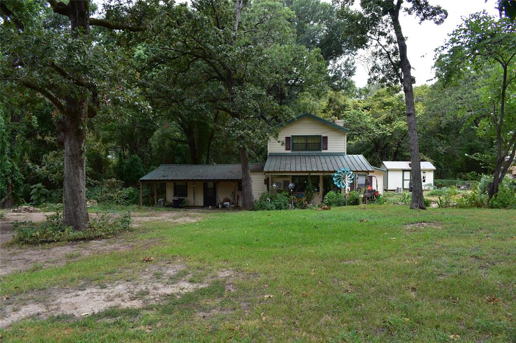 a front view of a house with a yard and trees